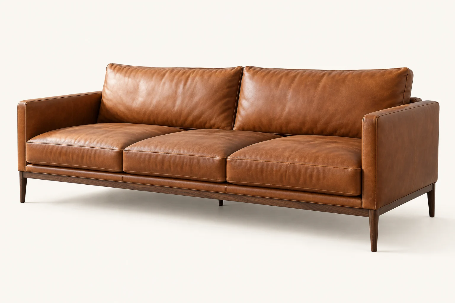 Divan cognac en cuir aux lignes droites, sur une structure en bois foncé.